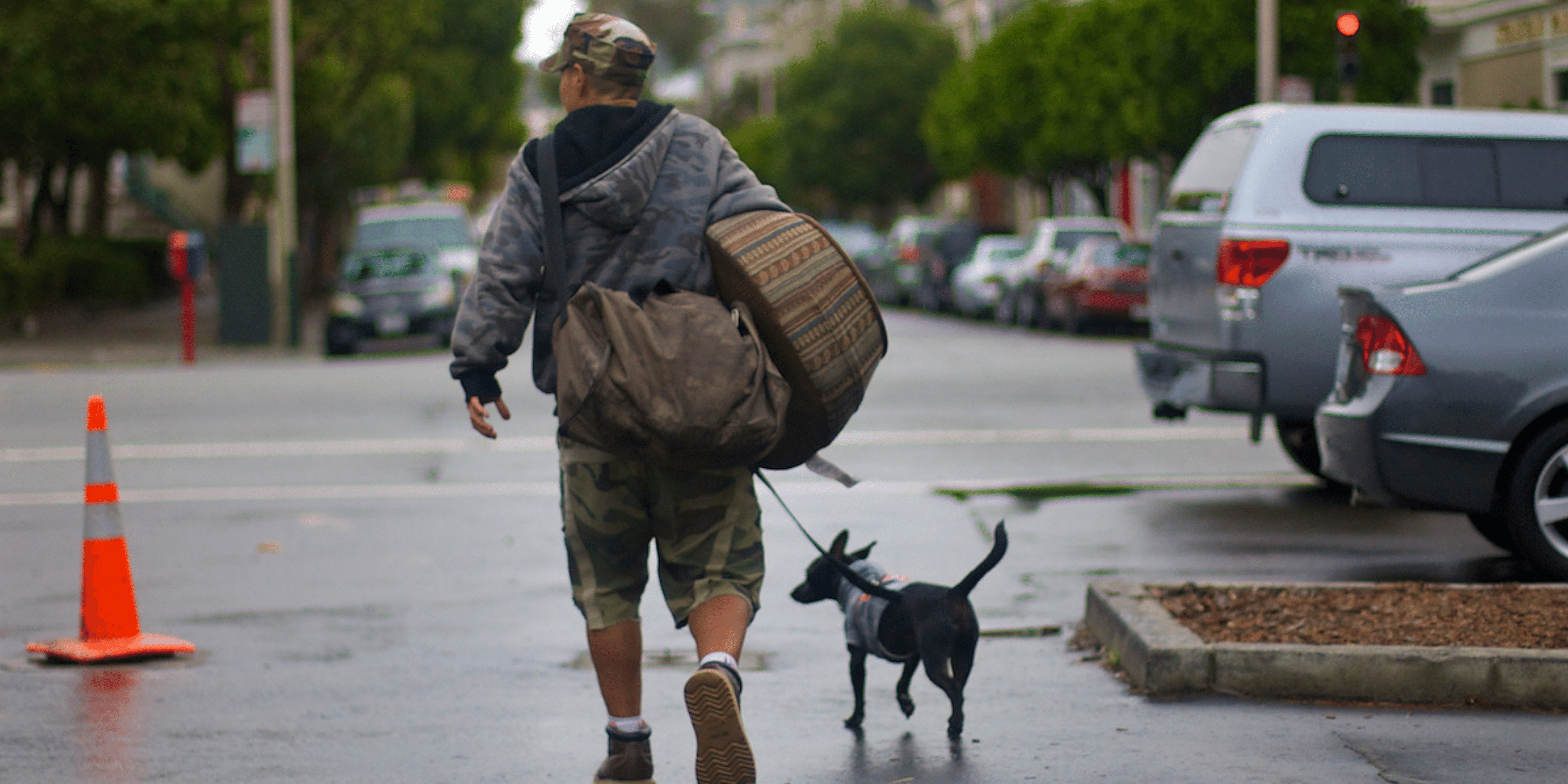 Photo of man walking dog with bags on back. By Mark Rogers Photography